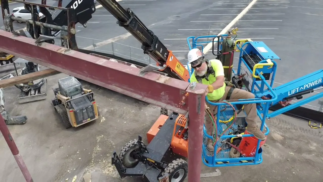 Bryant Built crew member in a lift basket torch-cutting a steel beam